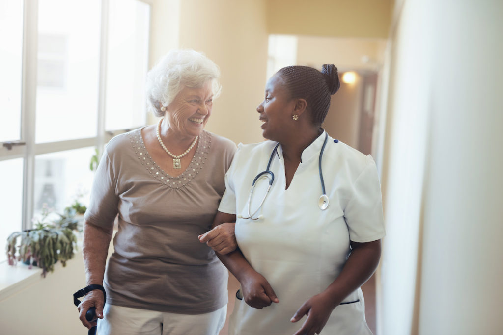 Nurse assisting senior woman at nursing home
